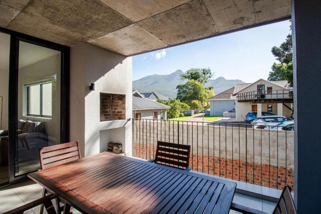 Modern balcony with wooden dining table overlooking mountain views