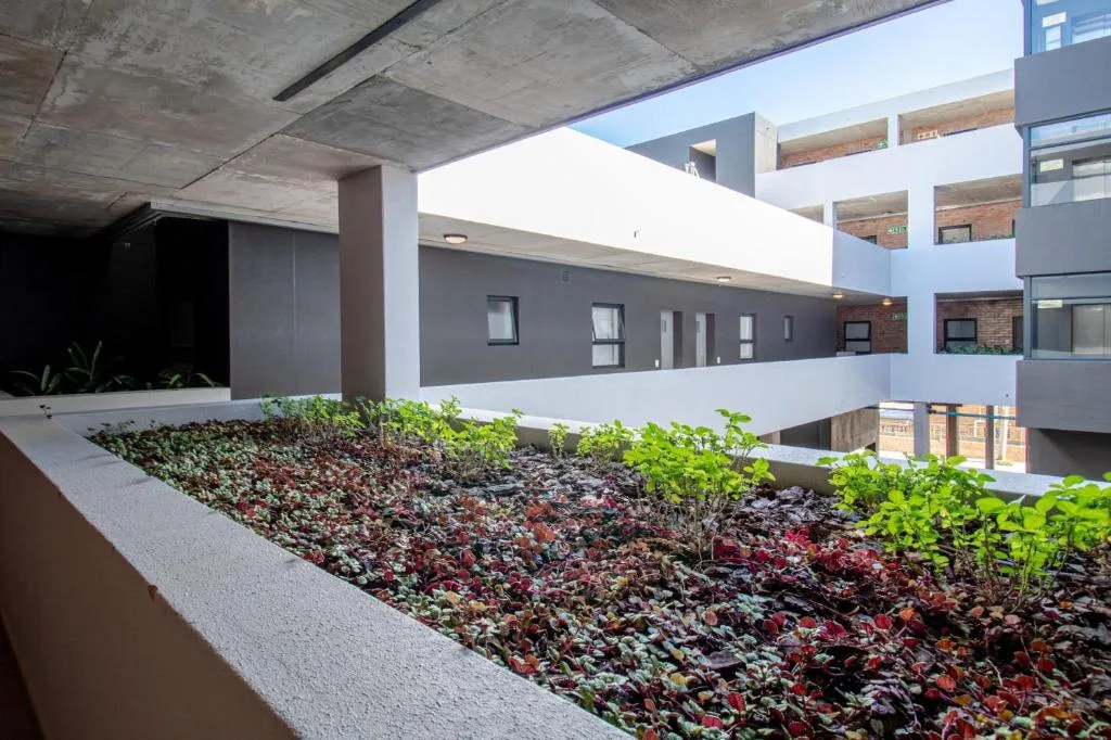 Modern apartment building courtyard with landscaped planter beds and greenery