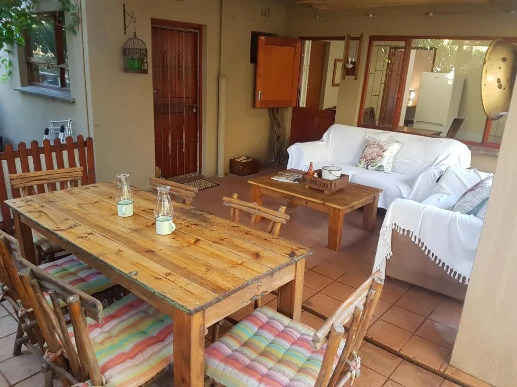 Wooden dining table with colorful cushioned chairs in open-plan interior