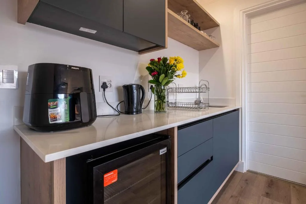Modern kitchen with black appliances, white countertop, and fresh flowers in vase