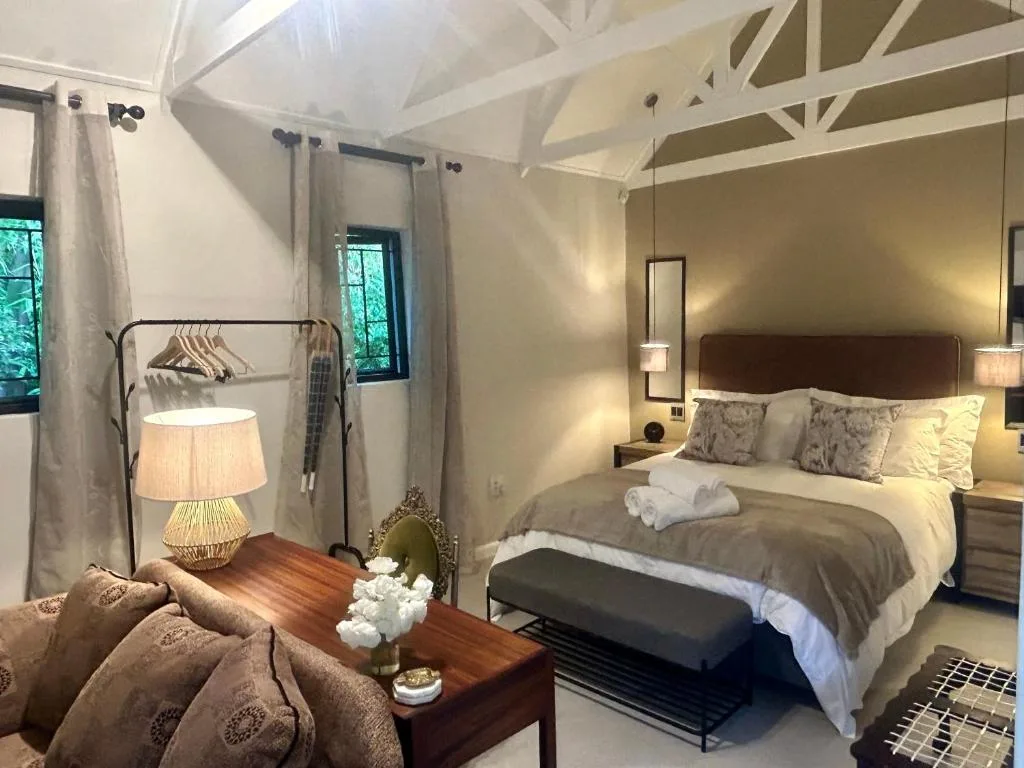 Spacious bedroom with queen bed, exposed beams, and natural light