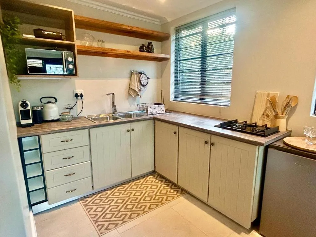 Modern kitchen with cream cabinetry, wooden countertops, and stainless steel appliances