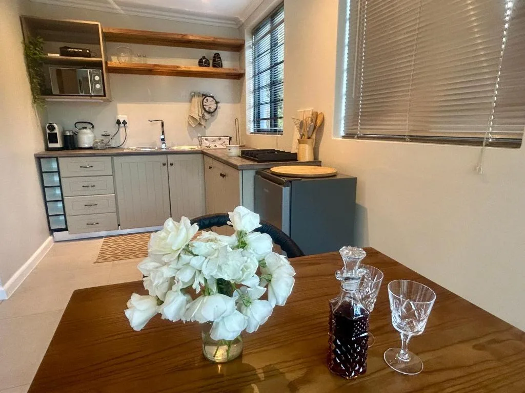 Modern kitchen with wooden countertops, white cabinetry, and open shelving