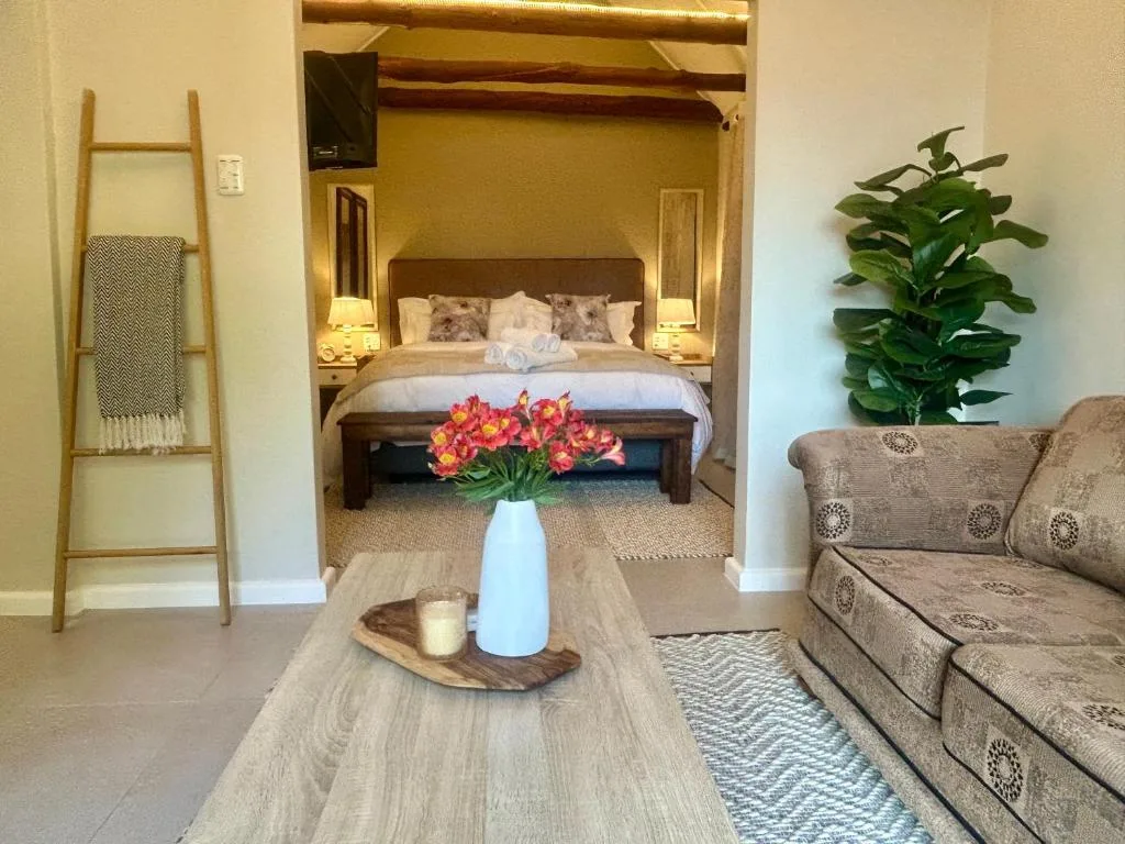 Open-plan lounge with sofa, coffee table, and ensuite bedroom visible through archway