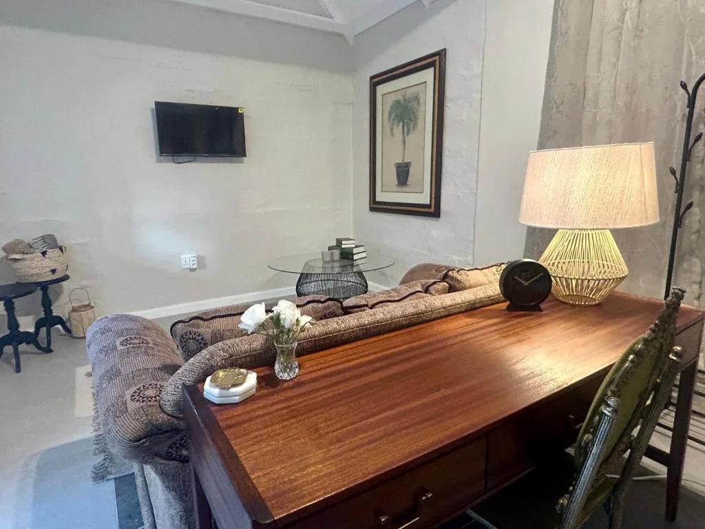 Modern living area with sofa, wooden desk, TV, and contemporary decor