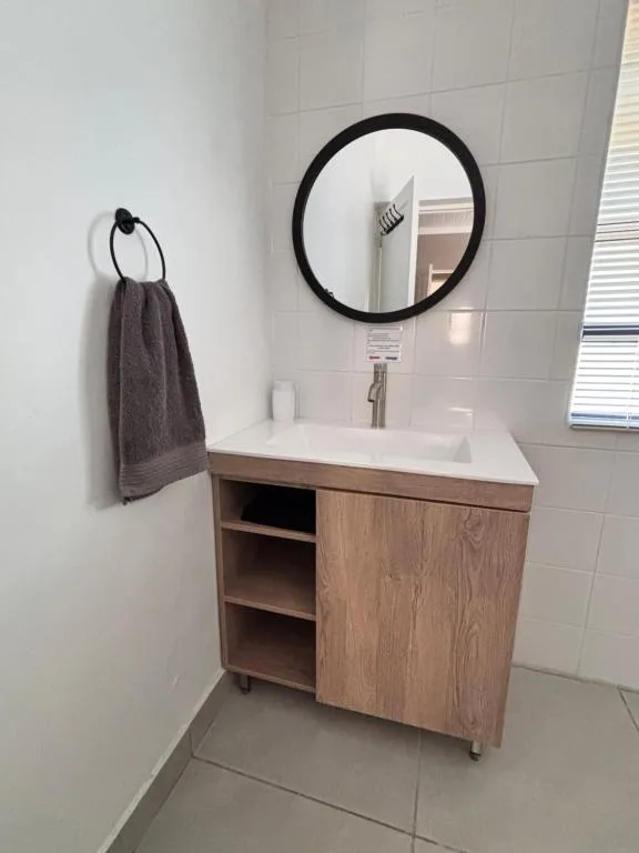 Modern bathroom vanity with round mirror and towel rack