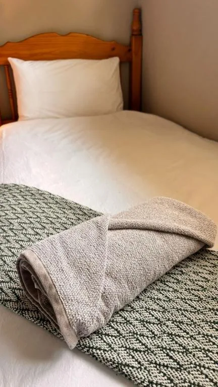 Wooden bed with white pillows and neatly folded blankets