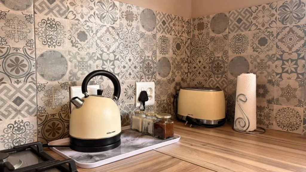 Cream kettle and toaster on kitchen counter with patterned backsplash tiles