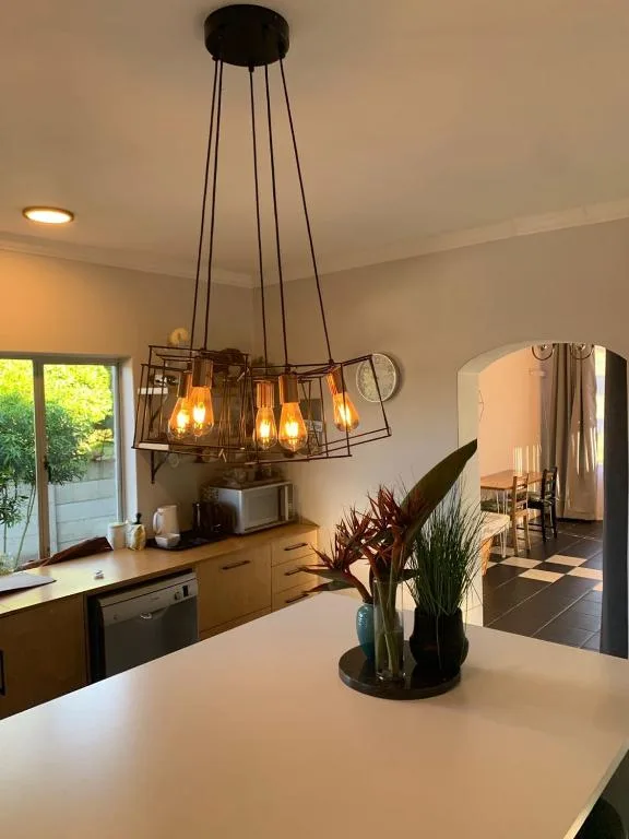 Modern pendant light fixture with glass shades above kitchen counter