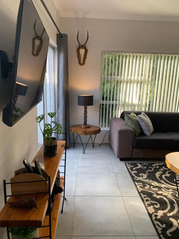 Modern lounge with black sofa, mounted TV, and mounted antelope decor