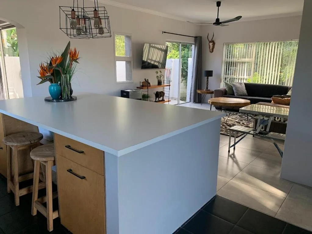 Open-plan living area with kitchen island, sofa, and garden views