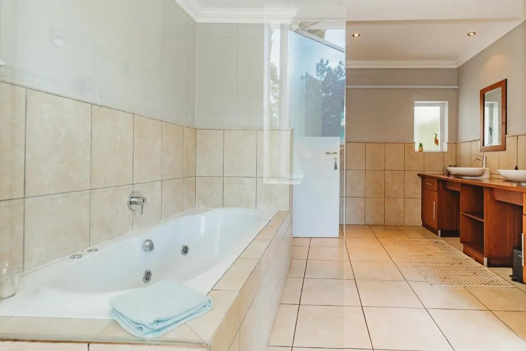 Spacious bathroom with jacuzzi tub, walk-in shower, double vanity, wooden cabinetry
