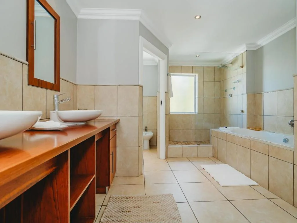 Spacious ensuite bathroom with dual vanities and walk-in shower enclosure