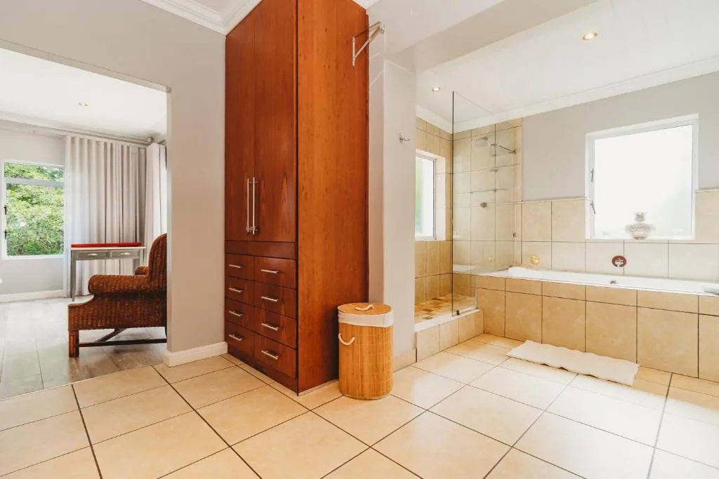 Spacious bathroom with walk-in shower, bathtub, and wooden cabinetry