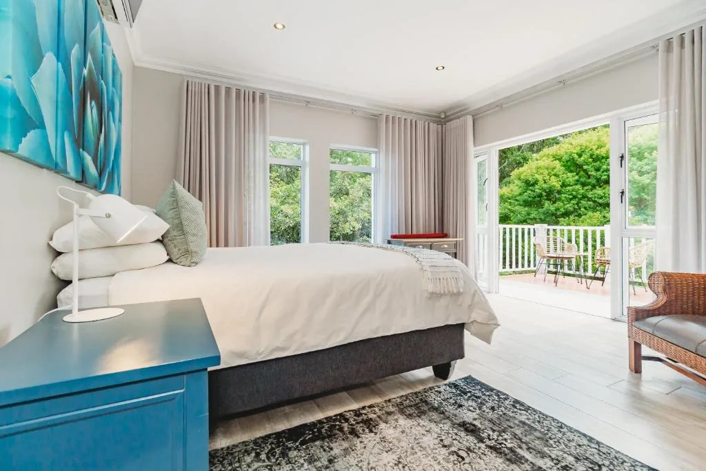Bright modern bedroom with queen bed, garden views through French doors
