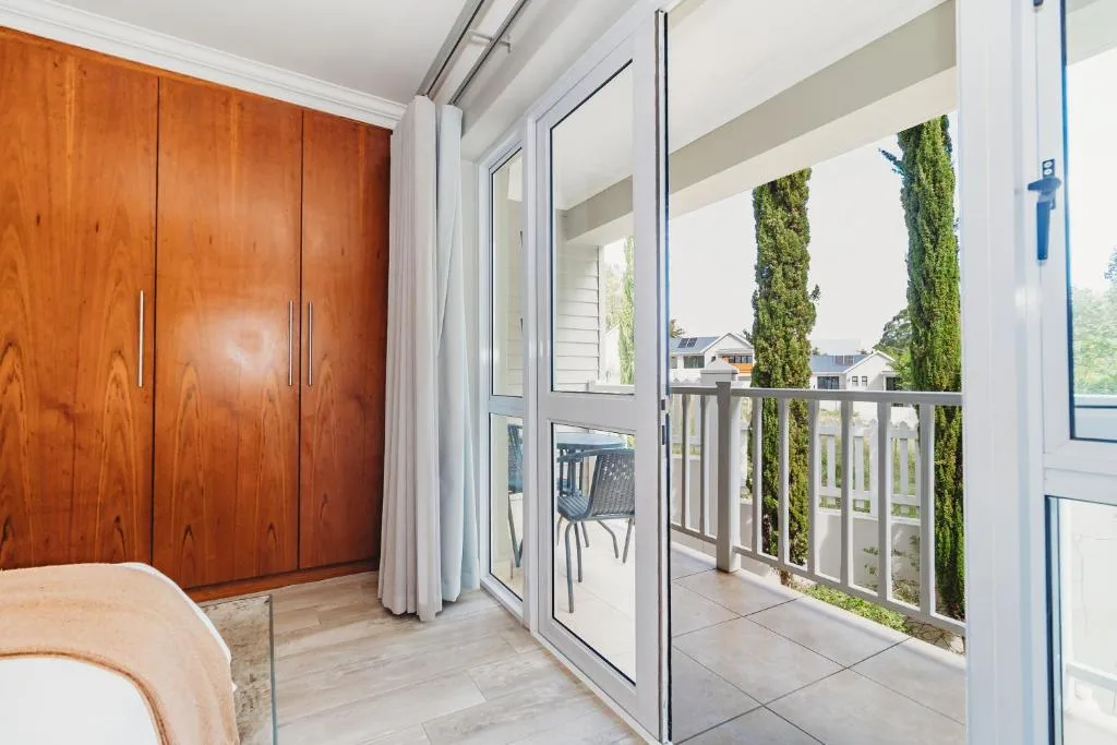 Modern bedroom with wooden wardrobe and glass sliding doors opening to deck