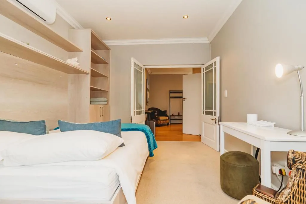 Spacious bedroom with queen bed, built-in wardrobes, and ensuite bathroom access