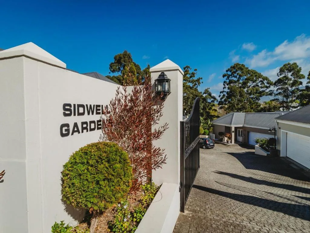 White modern entrance gate with Sidwell Gardens signage and manicured landscaping