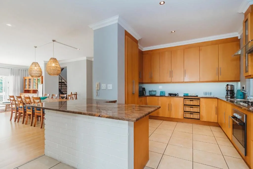 Spacious modern kitchen with wooden cabinetry and granite island bench