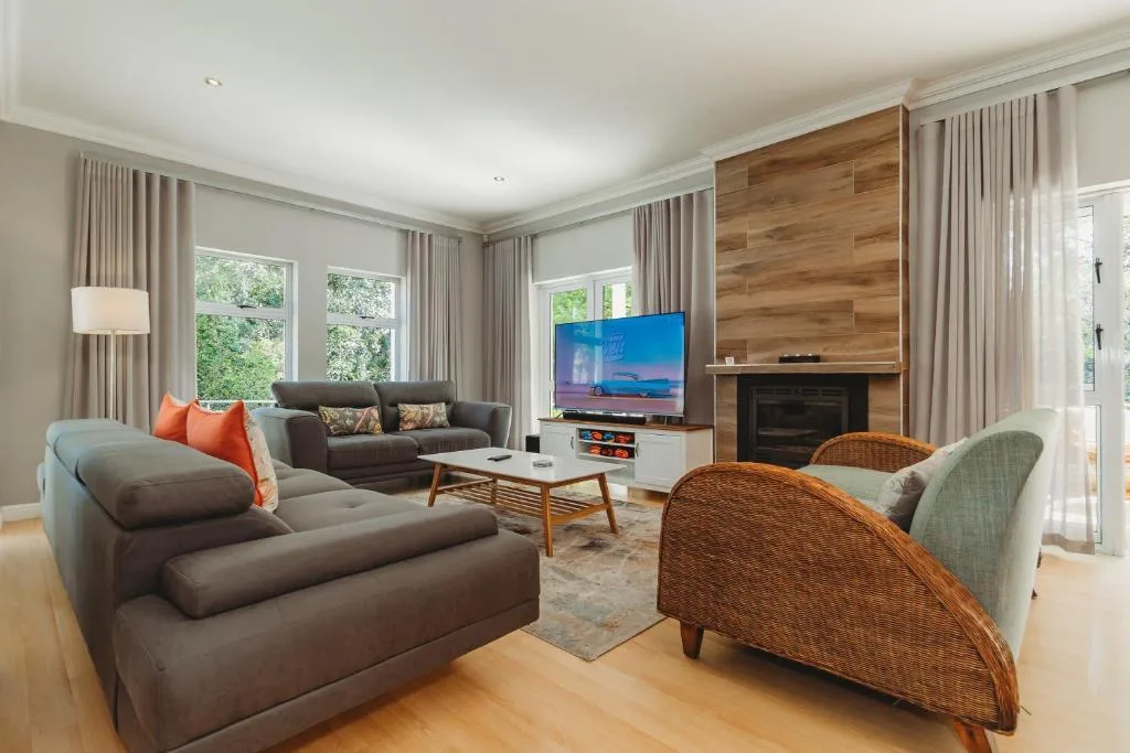 Spacious living room with gray sofas, fireplace, and modern TV setup