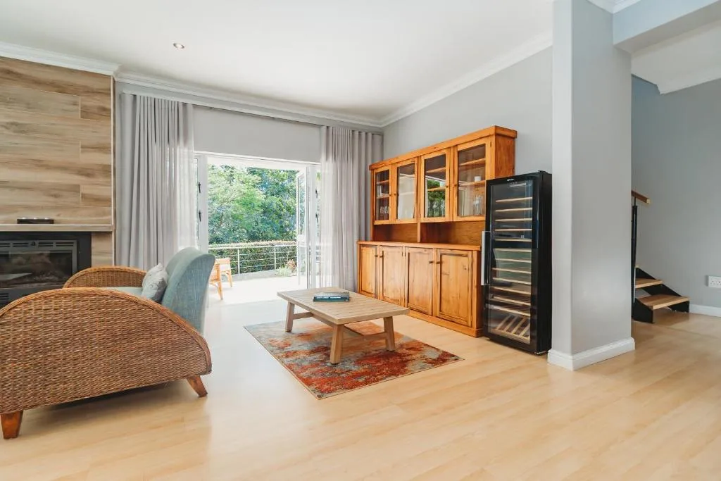 Bright lounge with wicker seating, fireplace, wooden furniture and garden views