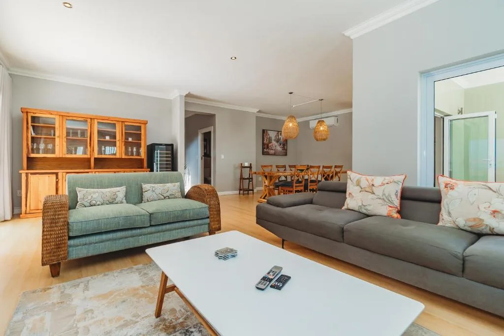 Spacious open-plan lounge with dual sofas, wooden furnishings, and pendant lighting