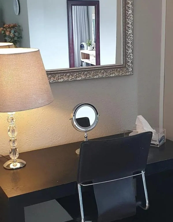 Bathroom vanity with lamp, mirror, and decorative framed mirror on wall