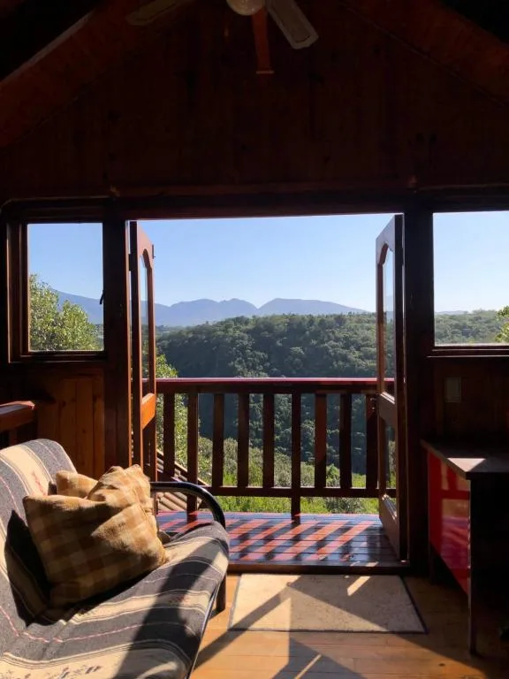 Mountain landscape vista framed by open deck doors and railing