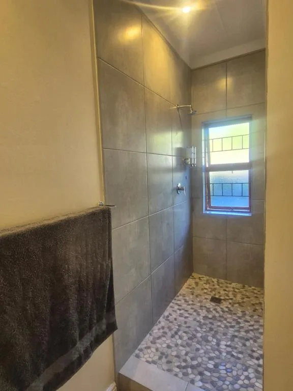 Modern bathroom with spacious walk-in shower enclosure and pebble flooring