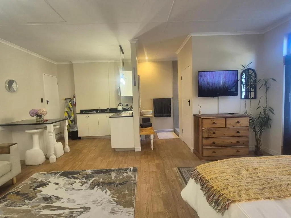 Open-plan cottage interior showing kitchen, living area, and bedroom spaces