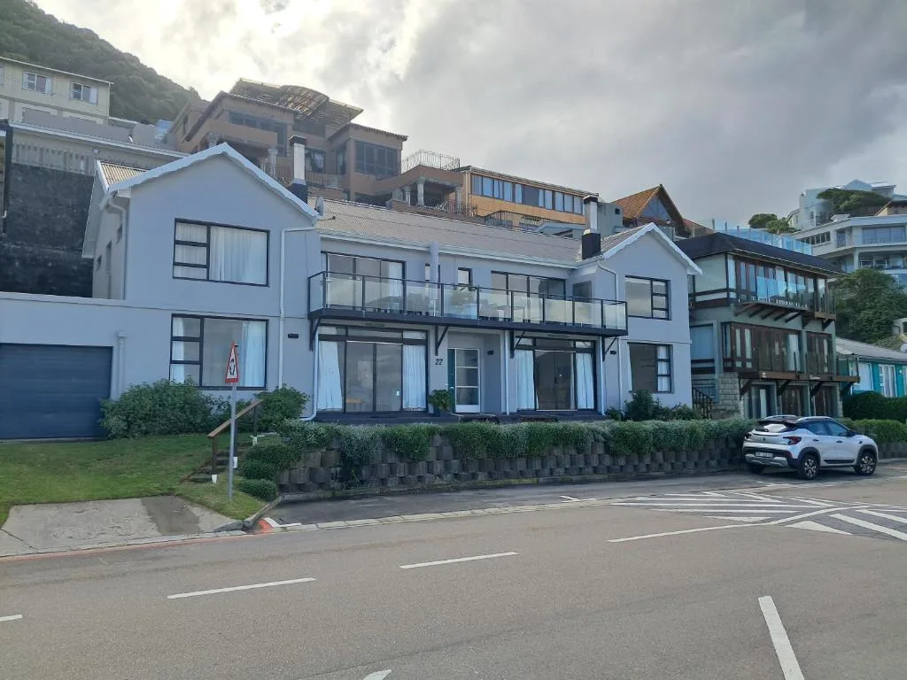 Modern white and grey beachfront building with balconies and garage