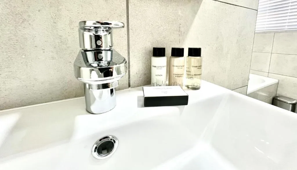 Modern bathroom vanity with chrome faucet and luxury toiletries