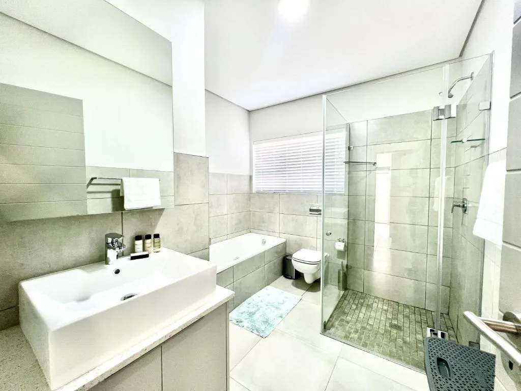 Modern bathroom with vanity sink, toilet, and spacious walk-in shower