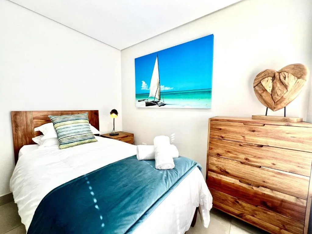 Cozy bedroom with wooden furniture and coastal nautical artwork