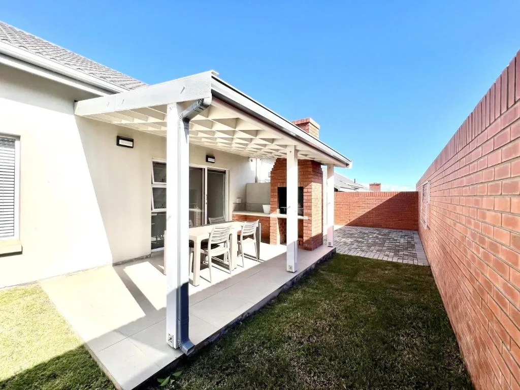 Modern covered patio with white pergola and outdoor seating area