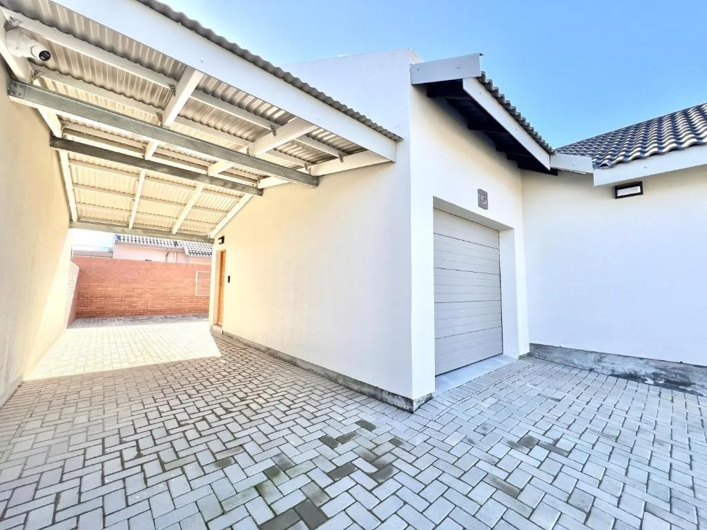 Modern white house with garage and paved driveway entrance