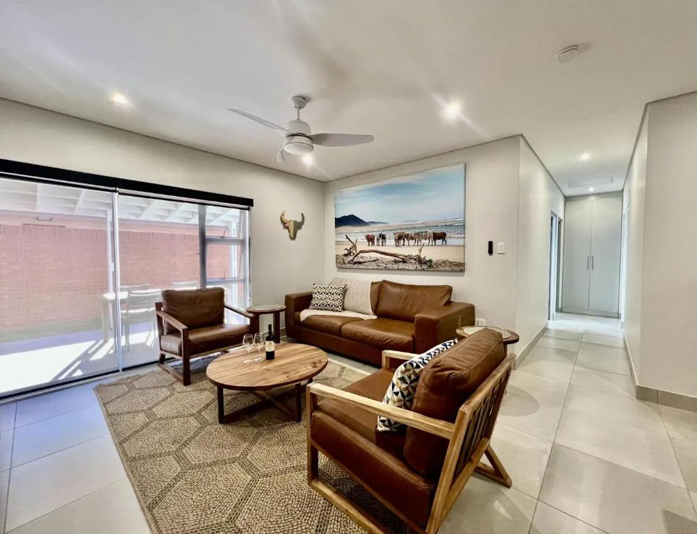 Modern living room with leather sofas, wooden coffee table, and wildlife artwork
