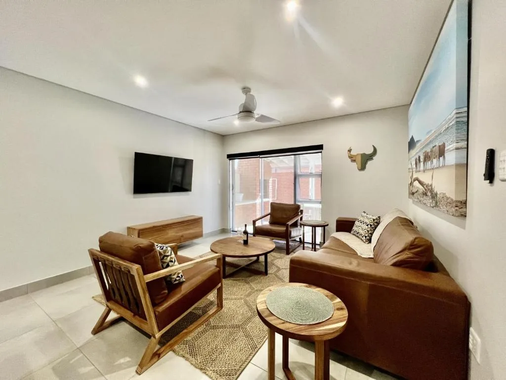Modern living room with brown leather seating and wooden furniture