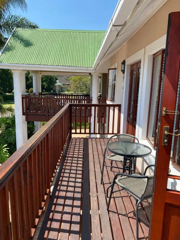 Wooden deck with outdoor seating and green corrugated roof