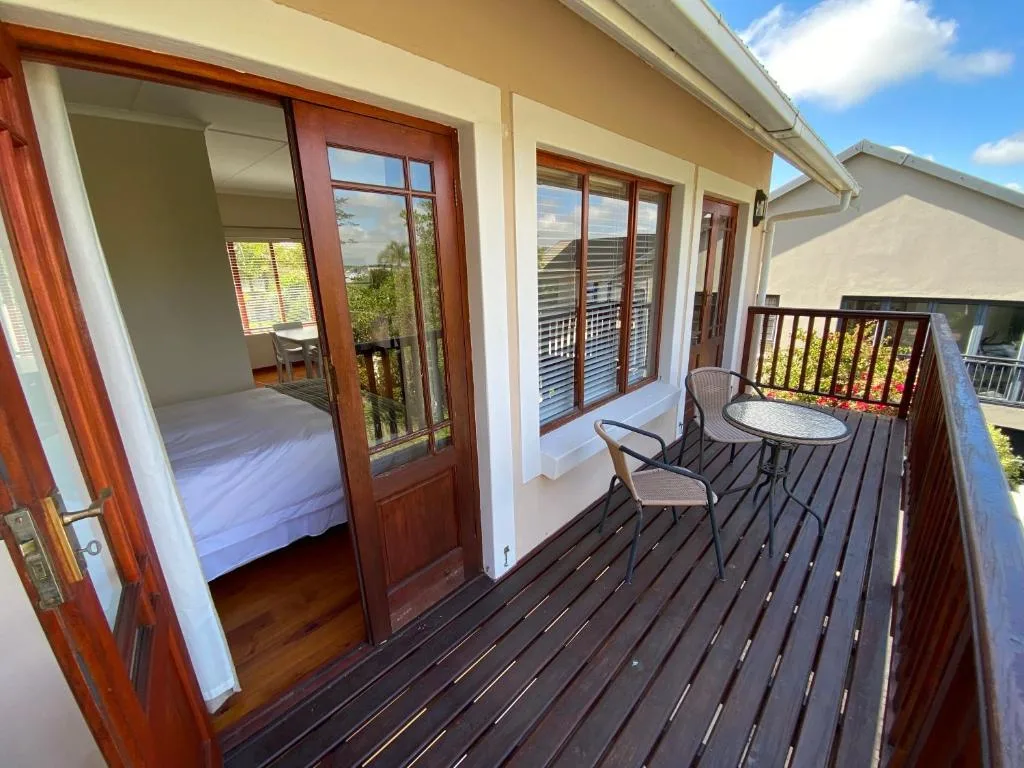Dark wooden deck with outdoor seating overlooking garden and mountains