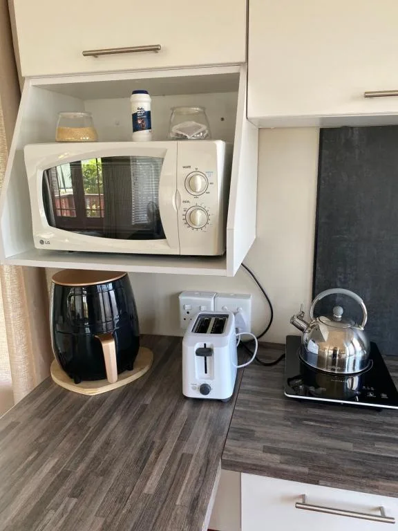 Kitchen counter with microwave, kettle, toaster and appliances