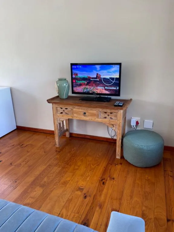 Living room with wooden TV stand, wall-mounted flat screen, and exercise ball