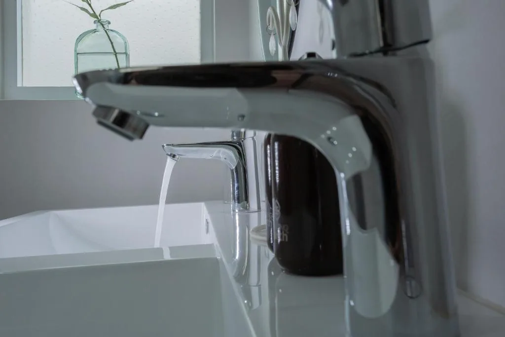 Modern bathroom vanity with chrome faucet and running water