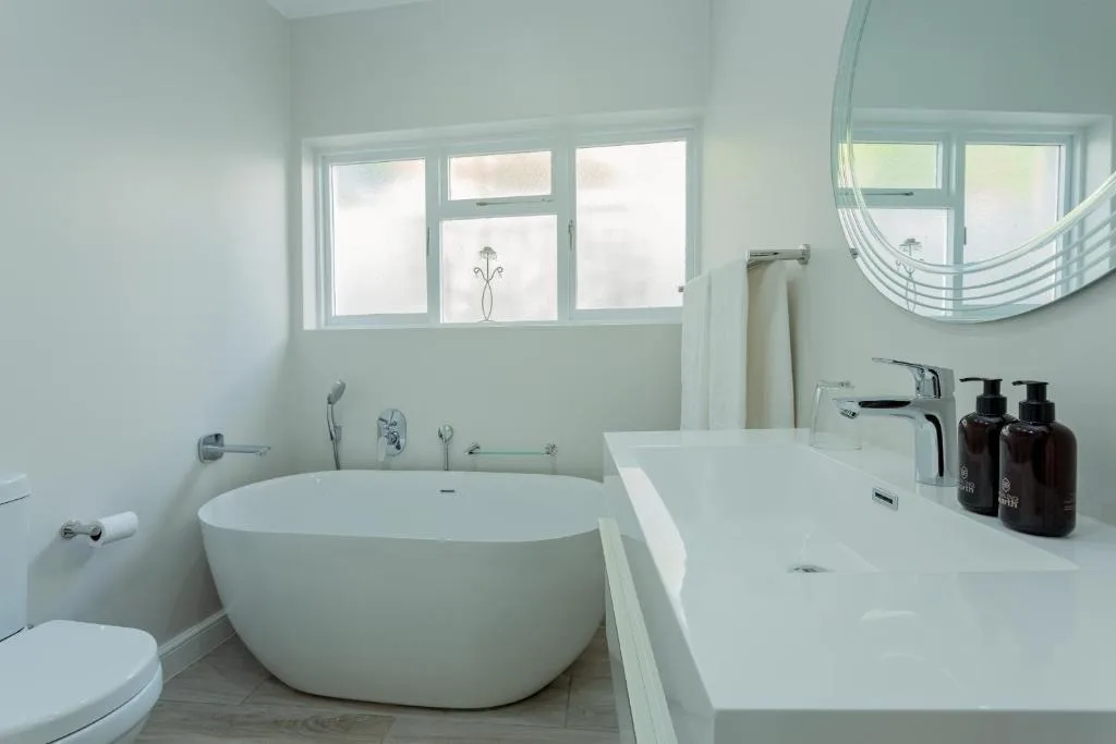 Modern bathroom with freestanding white bath tub and double vanity