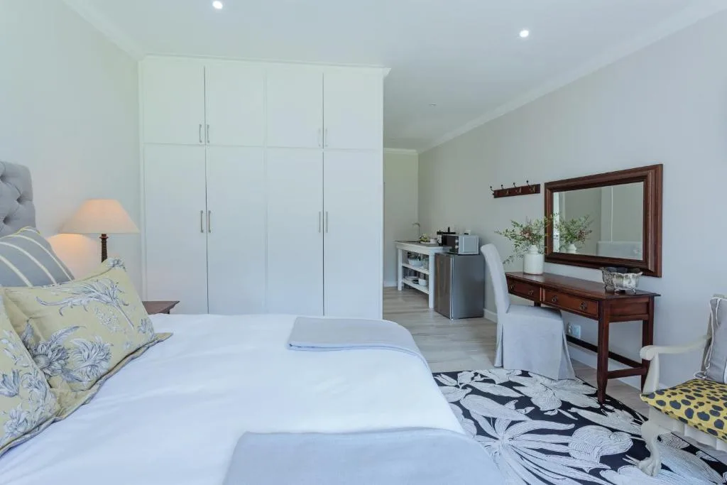 Spacious bedroom with twin beds, white cabinetry, and wooden vanity desk