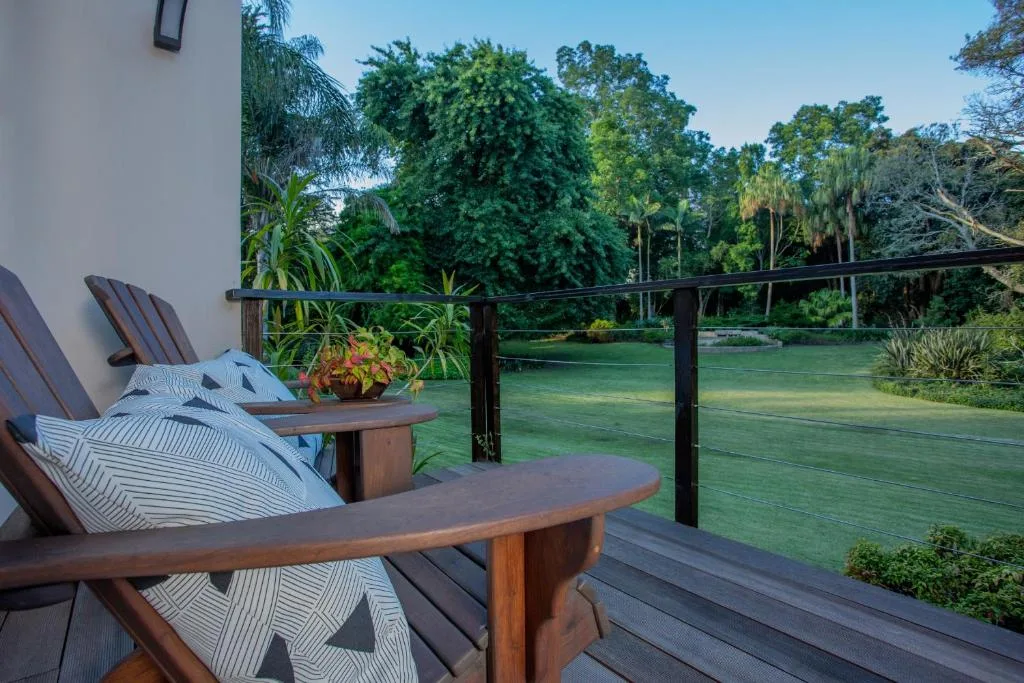 Wooden deck with lounge chairs overlooking lush green gardens and lagoon