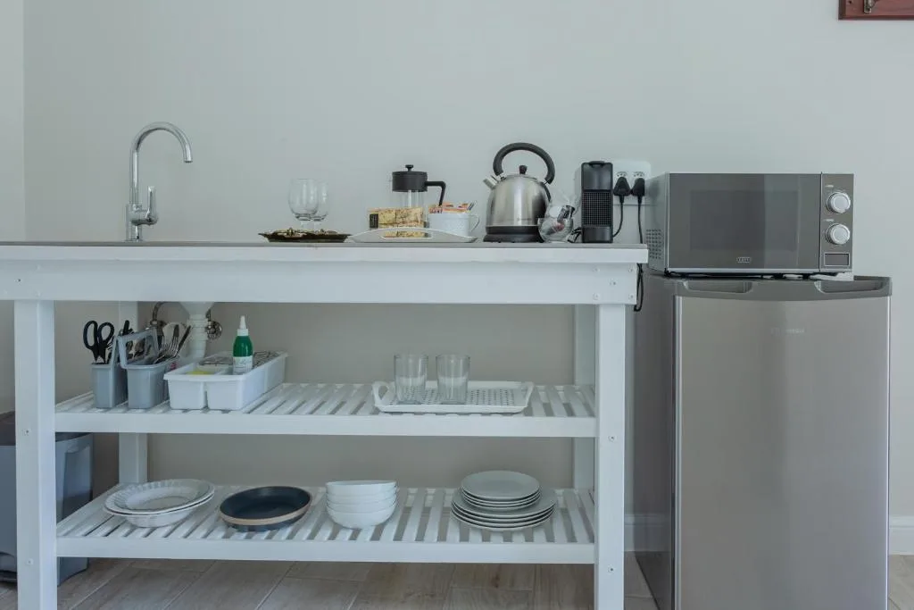 Compact kitchen with open shelving, refrigerator, and basic appliances