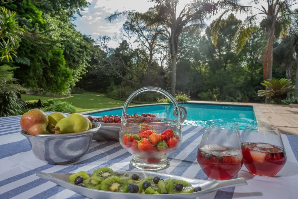 Swimming pool with garden views, refreshments on poolside table