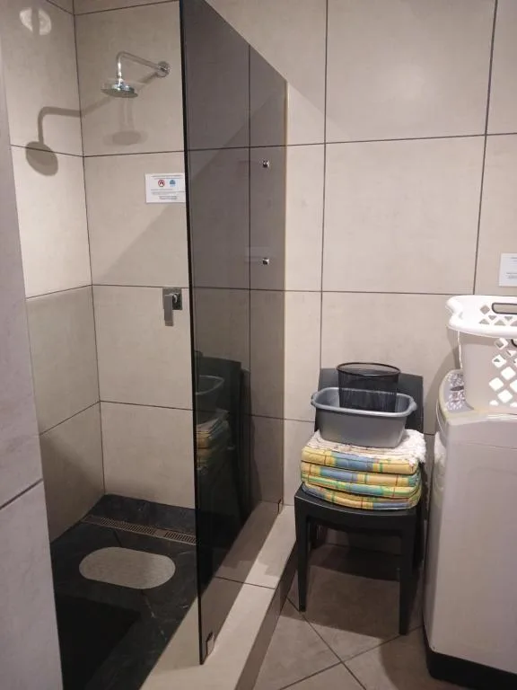 Modern bathroom with glass-enclosed shower and towel storage