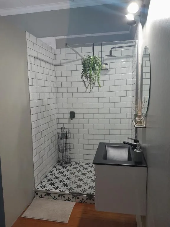 Modern bathroom with white subway tiles, black vanity, and rainfall showerhead